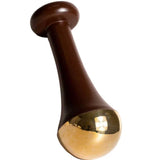 The LAMAV Ayurvedic Kansa Wand features a brown handle with a flared design and a rounded, shiny gold-colored tip, ideal for facial massage to support lymphatic drainage and promote radiant, healthy skin.