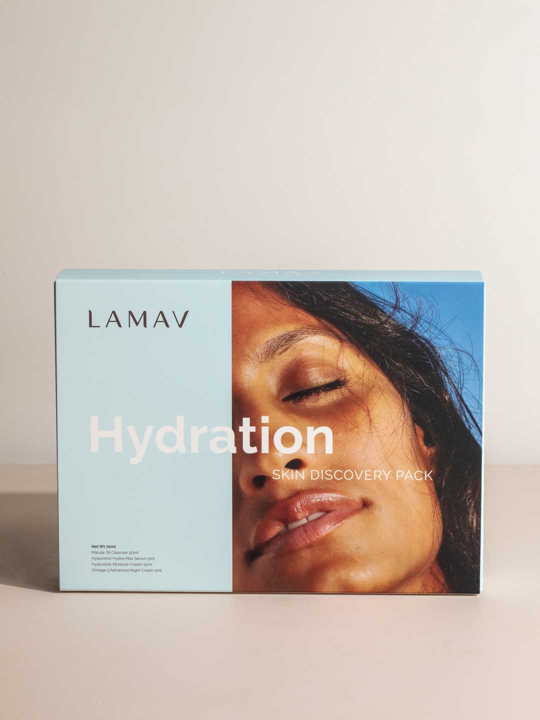 A box of LAMAV Hydration Skin Discovery Pack (4 Pack) displays a close-up of a peaceful woman's face against blue and beige, emphasizing LAMAV’s organic skincare and hyaluronic acid for deep hydration.