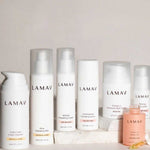 Seven LAMAV Age-Defence Complete Skincare Collection products for dry/sensitive skin—featuring creams, serum, mist, lotion, and oil—are arranged on a light background. Perfect for age defence and gentle care.