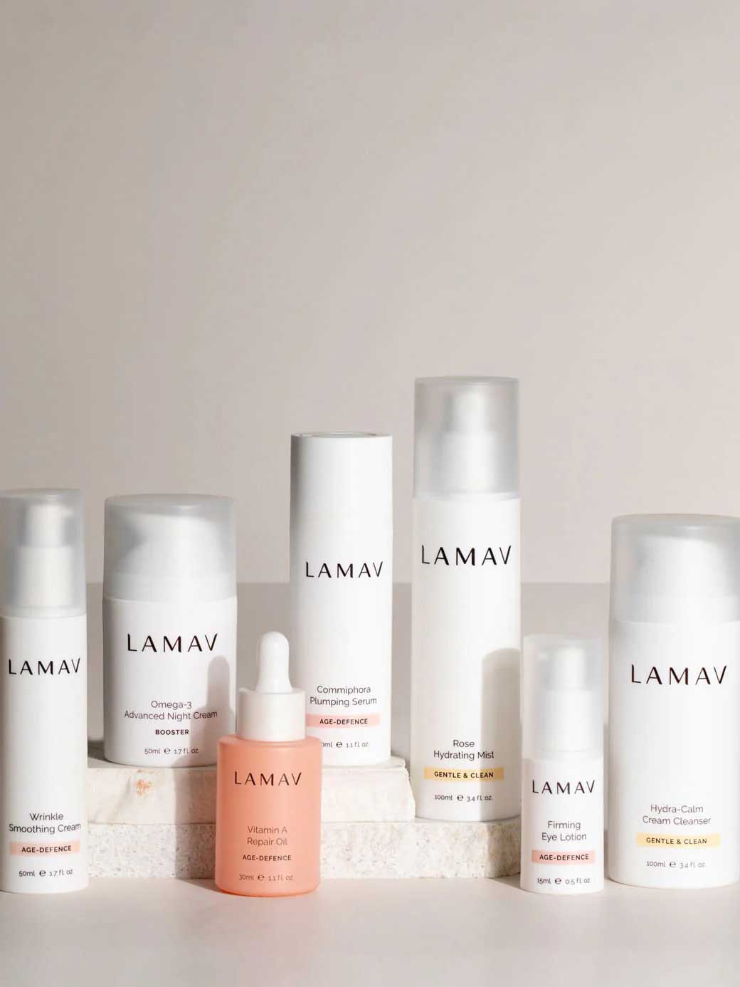 The LAMAV Age-Defence Complete Skincare Collection for Dry/Sensitive Skin (7 pack) features creams, serums, and lotions in white bottles and jars—ideal for sensitive skin; beautifully arranged on a light backdrop.