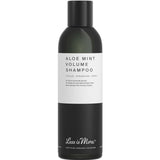 A black bottle of Less is More Aloe Mint Volume Shampoo 200ml with a white label shows its name and description. The certified organic shampoo is lightweight and volumising, as stated on the haircare label.