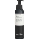 A black pump bottle labeled Less is More Flower Whip 150ml, an organic hair cream and styling finish for curls and wavy to frizzy hair. The white label with black text provides product information.