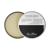A round metal tin of Less is More Kieselwax 50g, lid partially open to reveal light beige wax inside. The label describes it as an organic styling finish suitable for all hair types.
