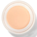 An open round pot of Alpine Rose Long Last Concealer, viewed from above, showing smooth pale peach beige cream within a white rim.