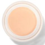 An open round pot of Alpine Rose Long Last Concealer, viewed from above, showing smooth pale peach beige cream within a white rim.