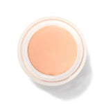 An open round pot of Crème Long Last Concealer, viewed from above, showing smooth pale peach cream within a white rim.