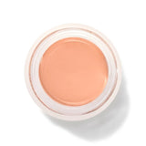 An open round pot of Golden Peach Long Last Concealer, viewed from above, showing smooth golden peach cream within a white rim.