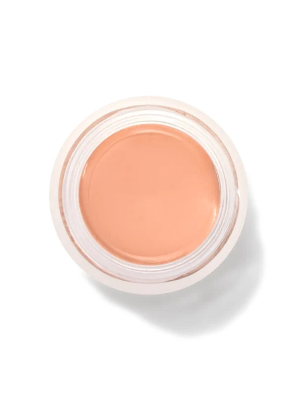 An open round pot of Golden Peach Long Last Concealer, viewed from above, showing smooth golden peach cream within a white rim.