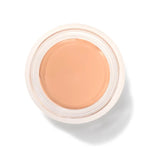 An open round pot of Peach Bisque Long Last Concealer, viewed from above, showing smooth warm peach beige cream within a white rim.