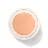 An open round pot of Peach Bisque Long Last Concealer, viewed from above, showing smooth warm peach beige cream within a white rim.
