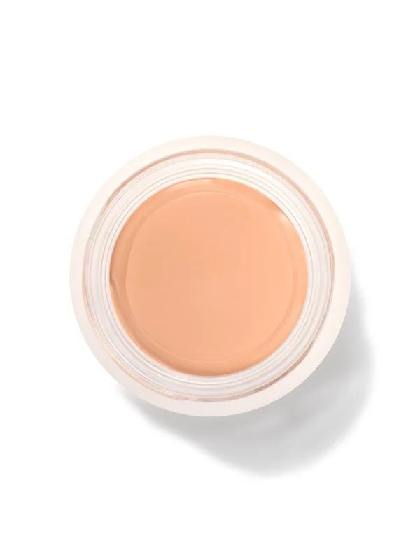 An open round pot of Peach Bisque Long Last Concealer, viewed from above, showing smooth warm peach beige cream within a white rim.