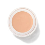 An open round pot of White Peach Long Last Concealer, viewed from above, showing smooth light peach beige cream within a white rim.