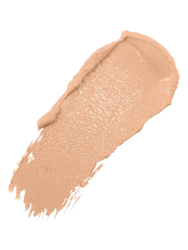 A diagonal swatch of White Peach Long Last Concealer in light peach beige, with a creamy sheen and a thick rounded end tapering into fine streaks.