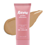A pink tube of RAWW Vitamin C BB Cream 30ml stands before a beige swipe, showcasing the hydrating formula with wildberry harvest, chia seed, and argan oil for a radiant complexion and creamy texture.