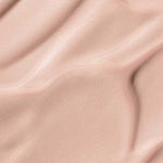 Soft, smooth beige fabric with gentle folds and shadows mirrors the finish of Madara H2O Tint Hyaluron Tinted Serum 30ml; “May Flower” appears at the bottom center.
