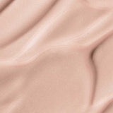 Soft, smooth beige fabric with gentle folds and shadows mirrors the finish of Madara H2O Tint Hyaluron Tinted Serum 30ml; “May Flower” appears at the bottom center.