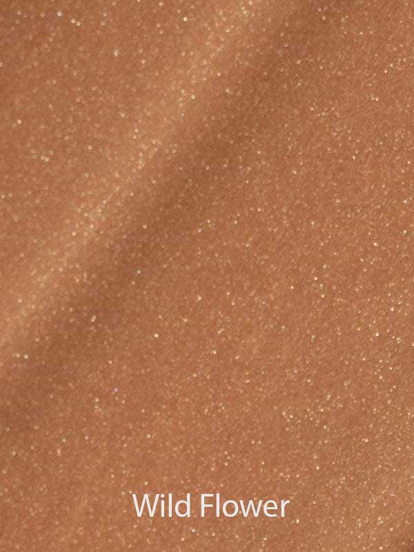 A close-up of shimmery light brown fabric with a glittery texture, evoking the radiant finish of Madara H2O Tint Hyaluron Tinted Serum 30ml. "Wild Flower" is written at the bottom in white text.