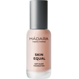 A frosted glass bottle of Madara Skin Equal Soft Glow Foundation SPF15 30ml with a matte silver cap and black text, featuring light pink-beige mineral foundation for a dewy finish.