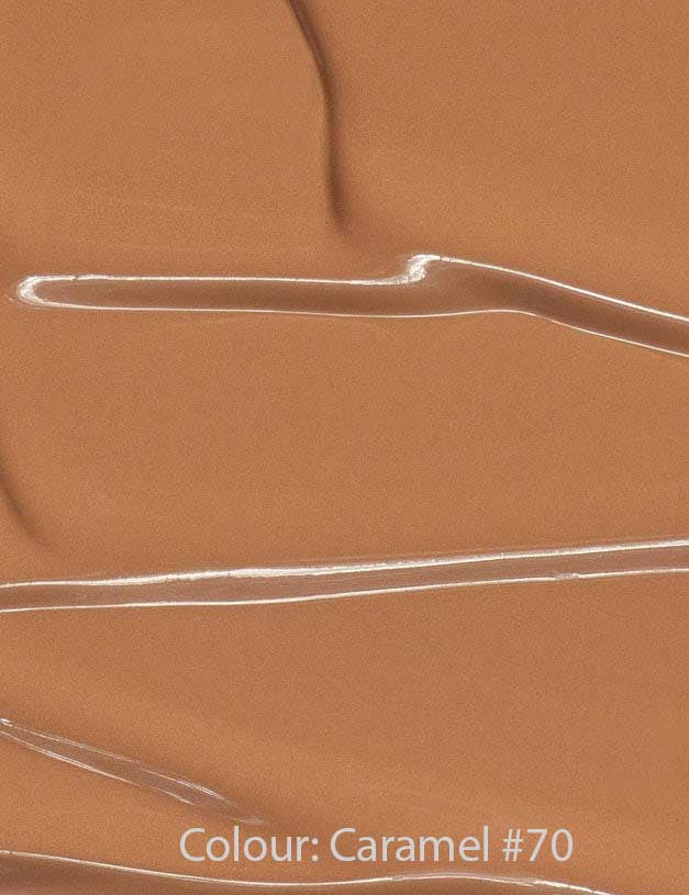 Madara Skin Equal Soft Glow Foundation SPF15 30ml in Caramel #70 swatched with glossy streaks and ripples, delivering a radiant, dewy finish. Colour: Caramel #70.