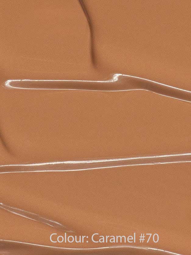Madara Skin Equal Soft Glow Foundation SPF15 30ml in Caramel #70 swatched with glossy streaks and ripples, delivering a radiant, dewy finish. Colour: Caramel #70.