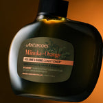 Antipodes Manuka and Orange Volume and Shine Conditioner bottle with product pour