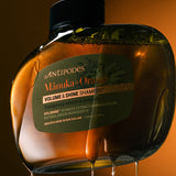 Antipodes Manuka and Orange Volume and Shine Shampoo bottle with product pour