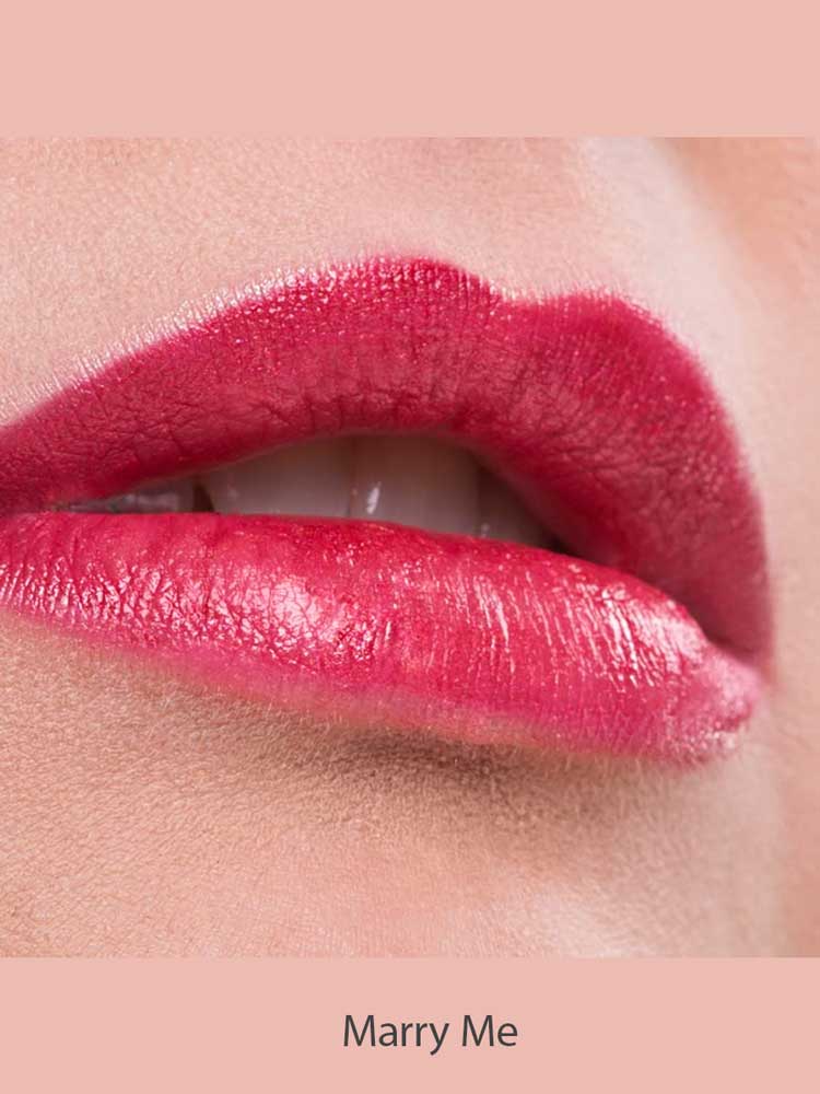 Close-up of lips wearing Benecos Natural Lipsticks 4.5g in bright pink, slightly parted to show teeth. The background is soft pink, with "Marry Me" written below the image.