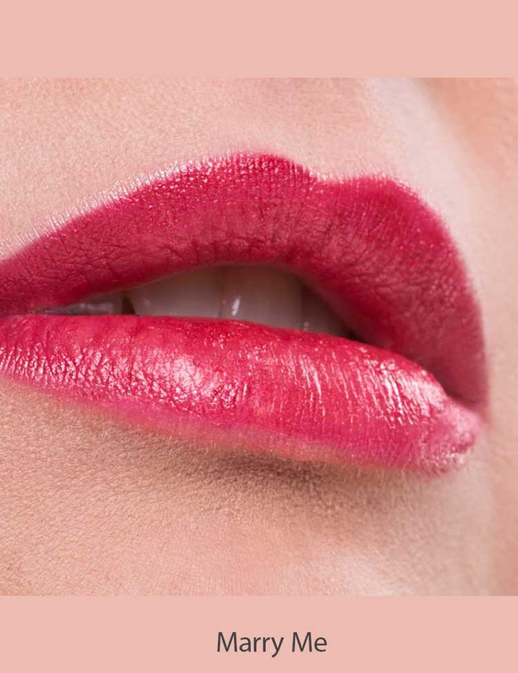 Close-up of lips wearing Benecos Natural Lipsticks 4.5g in bright pink, slightly parted to show teeth. The background is soft pink, with "Marry Me" written below the image.