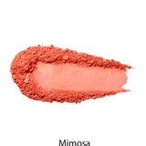A swatch of 100% Pure Rice Powder Pressed Blush 9g in peachy coral Mimosa is displayed on a white background, showcasing its natural flush and buildable coverage.