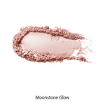 A swatch of light pink, shimmery powder—100% Pure Fruit Pigmented® Gemmed Luminiser 9g—is spread on a white background, reflecting radiant luminescence.