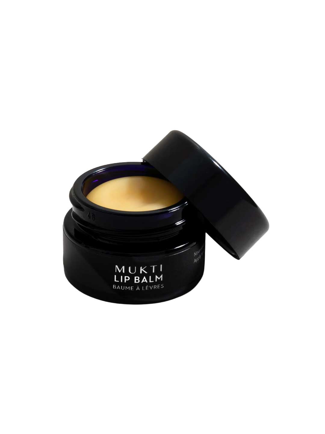 A black jar of Mukti Whipped Honey & Macadamia Lip Balm 9g with the lid resting beside it, showing the whipped golden balm made with certified organic ingredients.