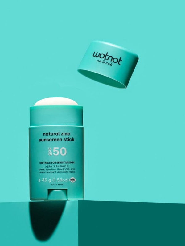 Open Wotnot Natural Zinc Sunscreen Stick SPF 50 on turquoise background
