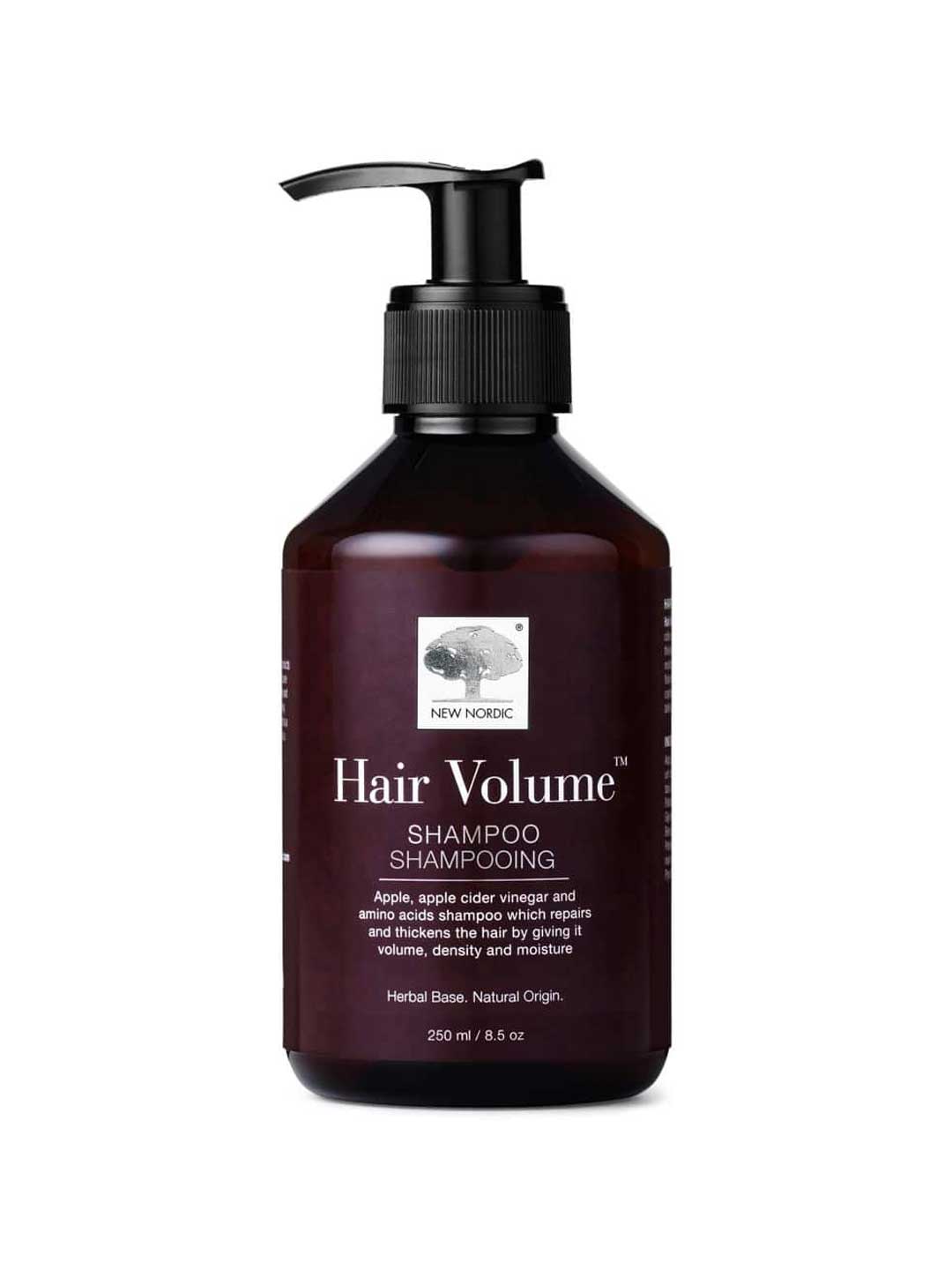 A dark brown pump bottle of New Nordic Hair Volume Shampoo 250ml, with white text and a tree logo. The natural formula highlights apple cider vinegar and amino acids on the label. Contains 8.5 oz (250 ml).