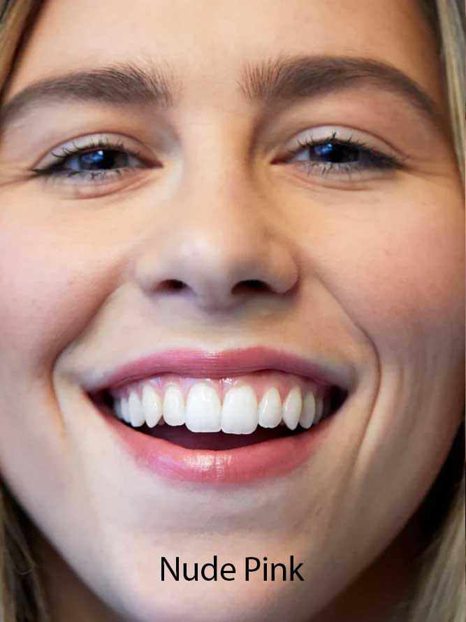 A close-up of a smiling woman with straight white teeth, wearing Luk Beautifood Lip Nourish Lipsticks 3g in nude pink. The text "Nude Pink" appears at the bottom of the image.