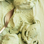 Close-up of Nutra Naturals Collagen Matcha Latte 100g with a gold spoon resting in the smooth, creamy, pale green surface.