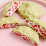 Four Nutra Naturals Collagen Strawberry Matcha Latte desserts, coated in organic Japanese matcha chocolate, are displayed on a pink plate—one whole and three sliced open to show the creamy strawberry filling.