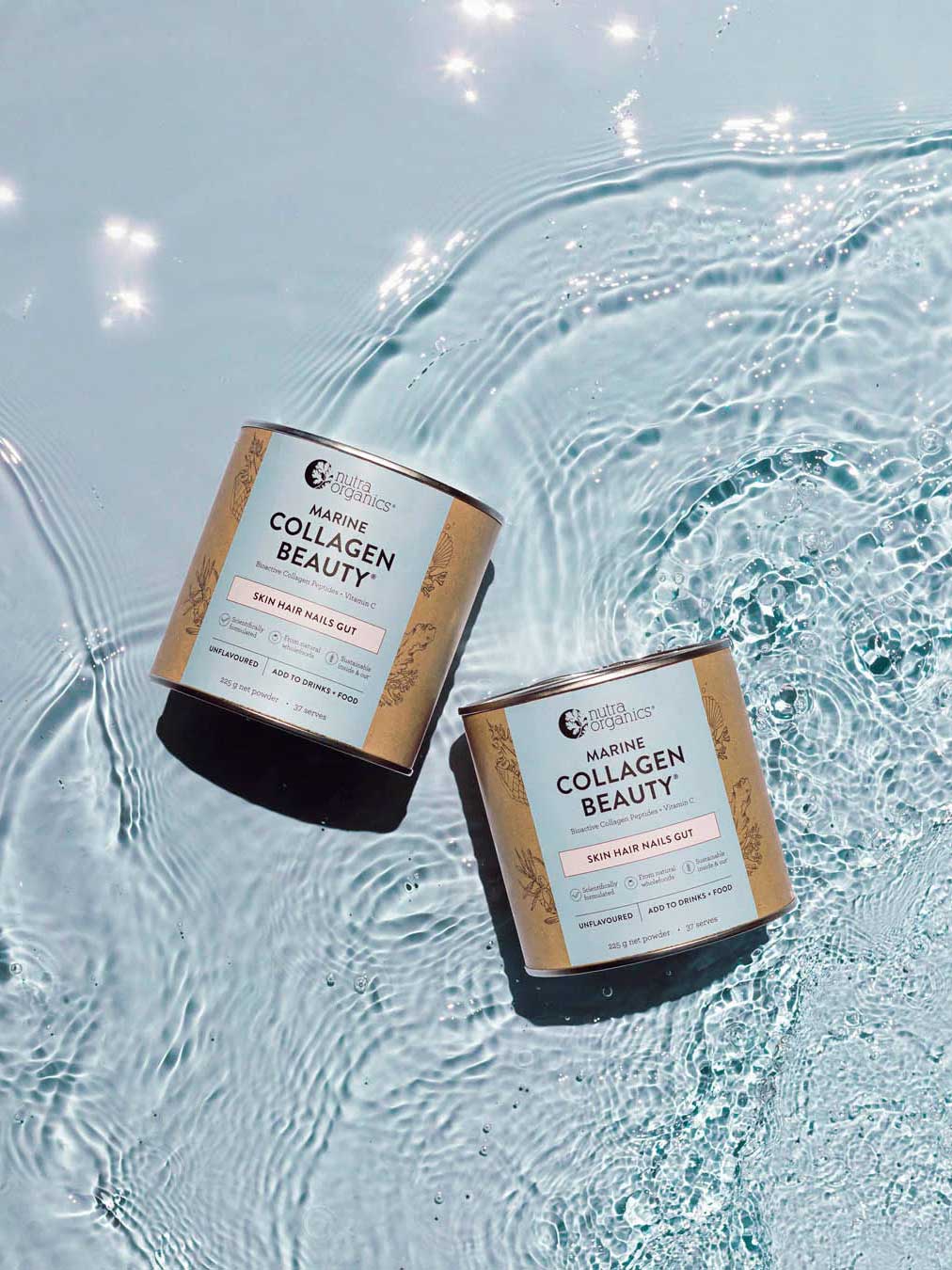Two jars of Nutra Naturals Marine Collagen Beauty Unflavoured 225g, with kraft paper labels in white, gold, and pink accents, sit on clear rippling water as sunlight shimmers around them.