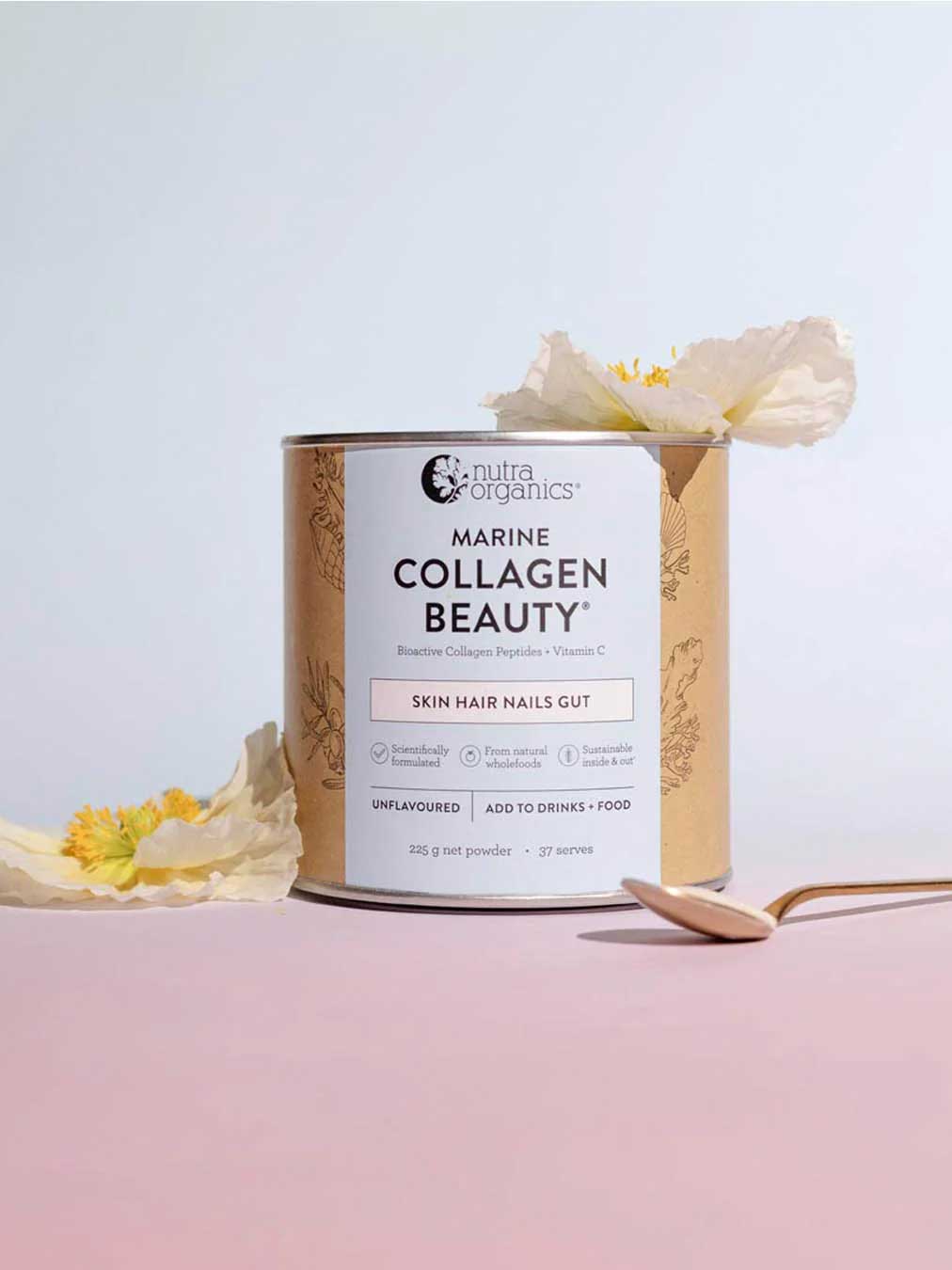 A canister of Nutra Naturals Marine Collagen Beauty Unflavoured 225g sits on a pink surface with a gold spoon and yellow-white flowers. This powder supports skin hydration and promotes healthy hair, nails, and gut.