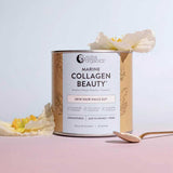 A canister of Nutra Naturals Marine Collagen Beauty Unflavoured 225g sits on a pink surface with a gold spoon and yellow-white flowers. This powder supports skin hydration and promotes healthy hair, nails, and gut.