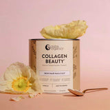 A container of Nutra Naturals Collagen Beauty Vanilla 225g is shown on a pink surface with pale yellow flowers and a gold spoon, featuring a label promoting benefits for skin, hair, and nails.