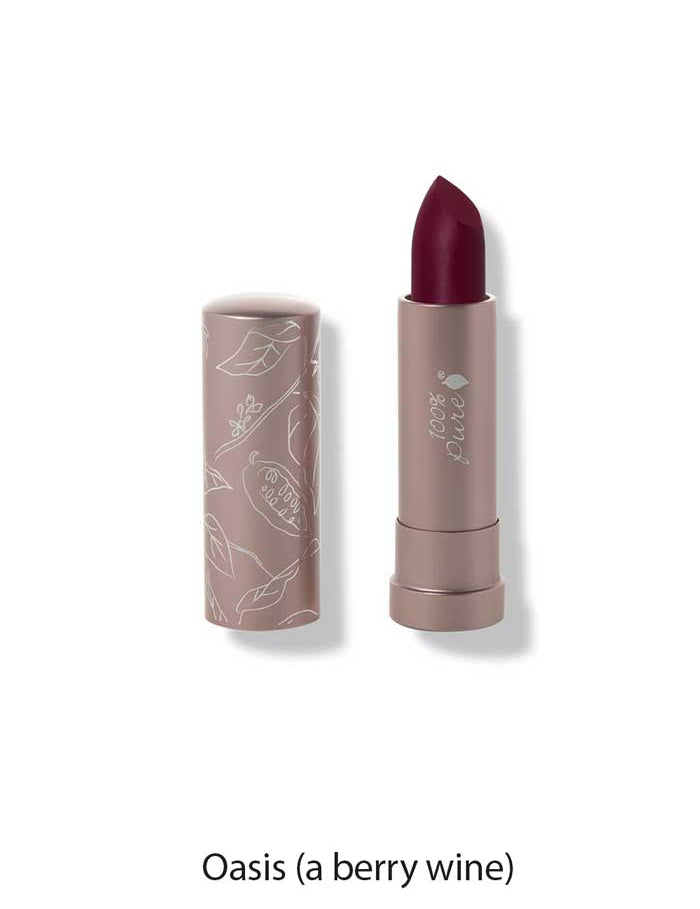 A 4.5g tube of 100% Pure Cocoa Butter Matte Lipstick in the shade Oasis (a berry wine), cap off to reveal the deep berry color. The light mauve tube is adorned with white botanical designs for an elegant touch.
