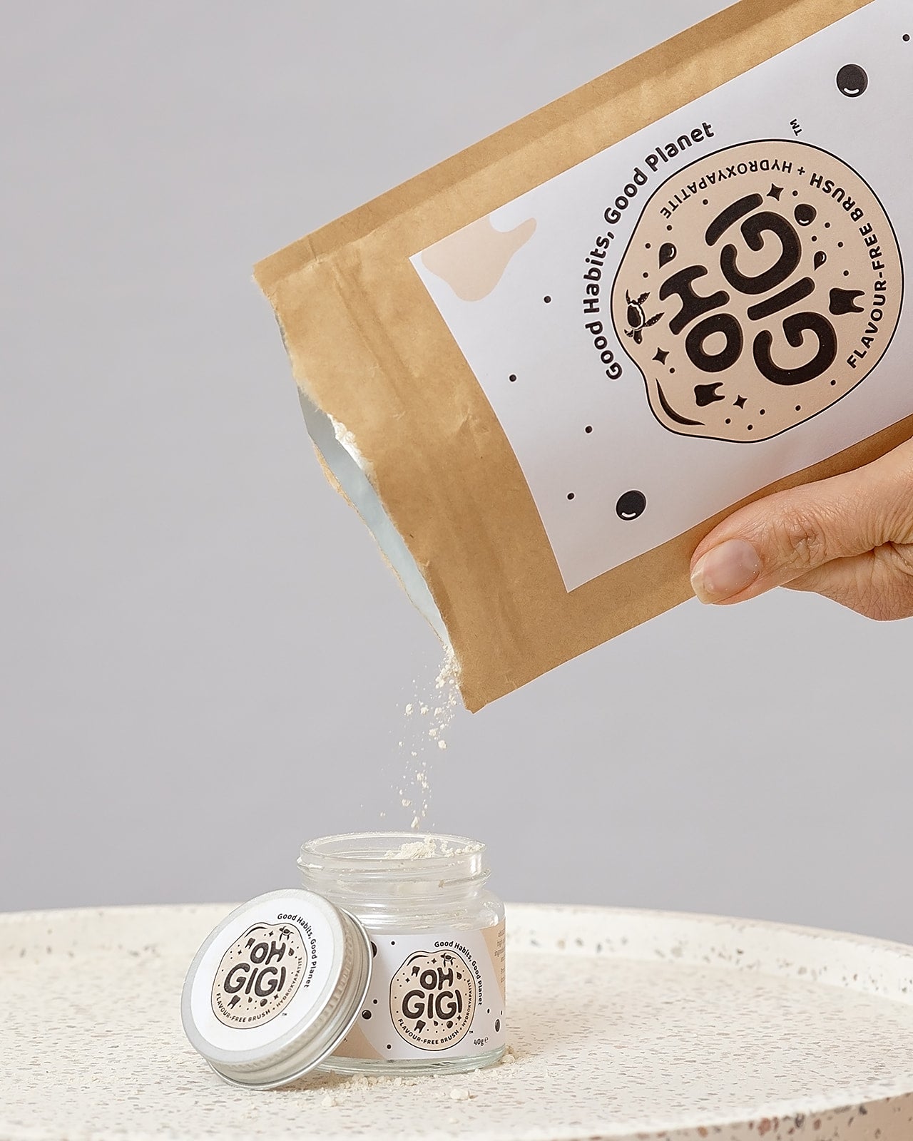 Oh Gigi Flavour-Free Hydroxyapatite Tooth Powder refill being poured into its glass jar
