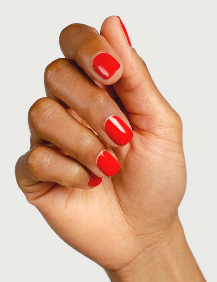 A close-up shows a hand with brown skin and neatly manicured nails painted in glossy Passion shade using Sienna Byron Bay Nail Polish (10ml), set against a plain light background.