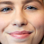 A close-up of a smiling woman’s face shows natural makeup with nourishing Luk Beautifood Lip Nourish Lipsticks 3g in a peach-toned shade. “Peach Melon” appears at the bottom of the image.