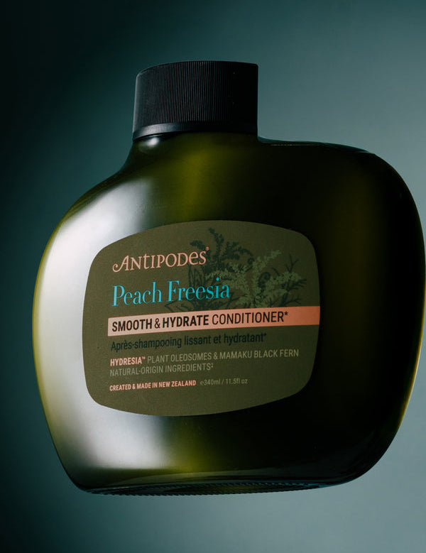 Antipodes Peach Freesia Smooth and Hydrate Conditioner bottle with product pour