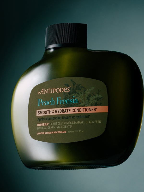 Antipodes Peach Freesia Smooth and Hydrate Conditioner bottle with product pour