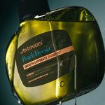 Antipodes Peach Freesia Smooth and Hydrate Shampoo bottle with product pour