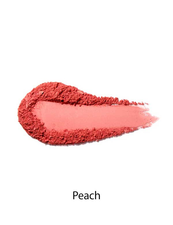 A smear of 100% Pure Rice Powder Pressed Blush 9g in peach on a white background, with "Peach" below, highlights its buildable coverage for a natural-looking flush.