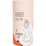 The Pelvi Lumi Turkish Silk Exfoliating Mitt is a cylindrical container holding a mitt that removes dead skin for glowing, brighter skin. The packaging features minimalist abstract art and text on a light peach background.