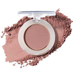 An open compact of 100% Pure Fruit Pigmented® Eye Shadow 2g by 100% Pure reveals matte mauve powder, some scattered nearby, resembling pressed powder blush against a clean white background.